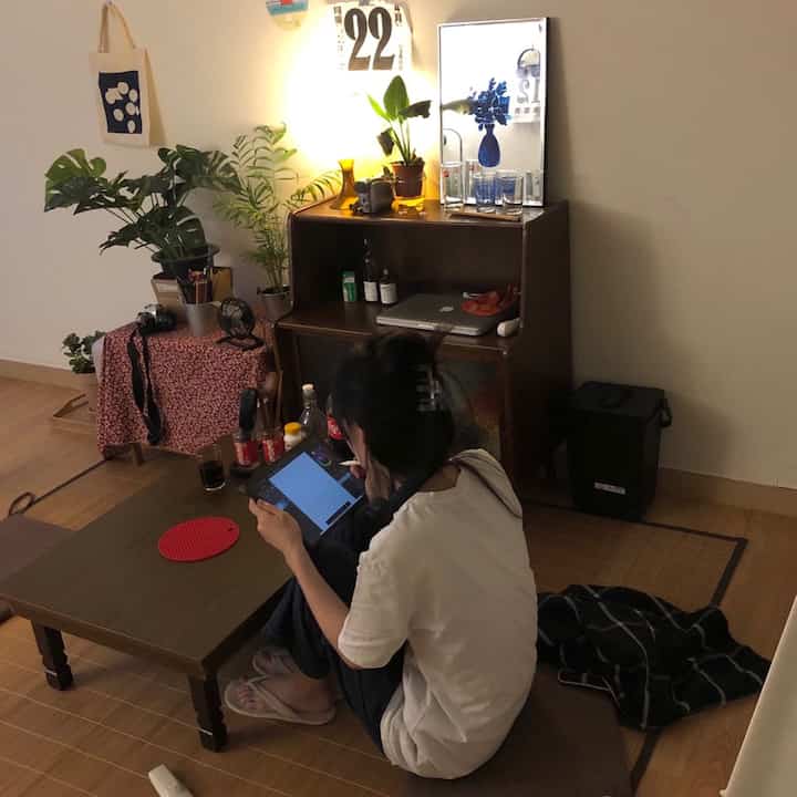 Cozy natural wood tone and beige small room featuring floor cushions and a vanity desk, set up as a home office and workspace