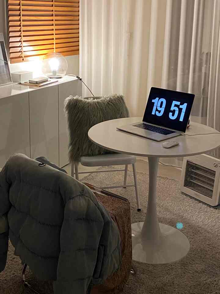 白を基調としたリビング、丸いダイニングテーブルとラグが配置され、温かみのある整った冬のインテリア