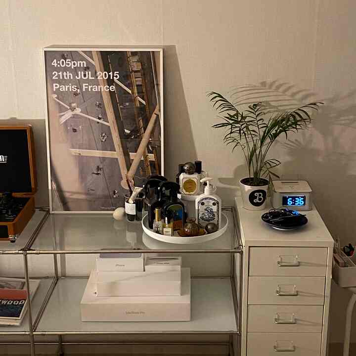 White-toned room featuring metal dresser, large picture frame, and plant in a clean modern interior