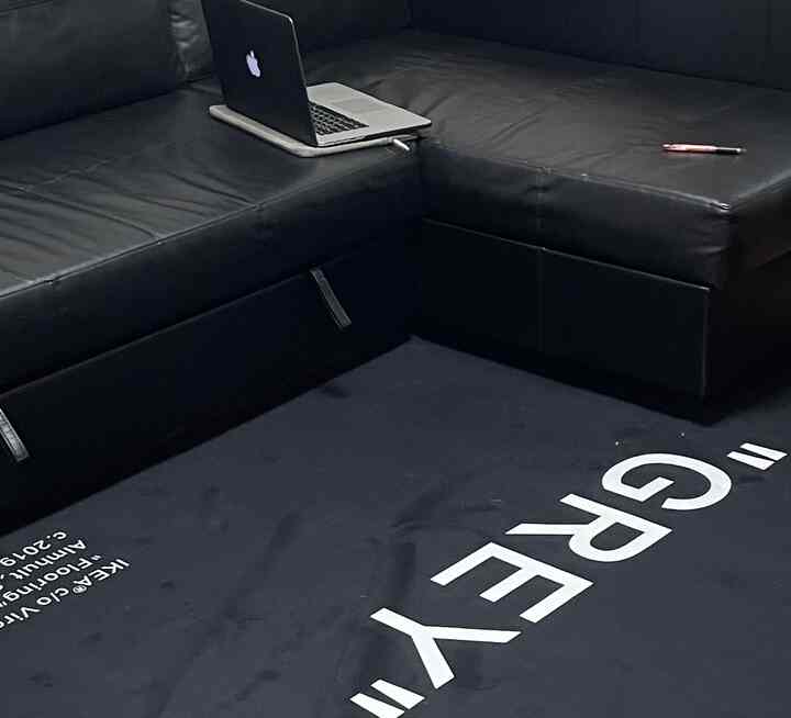 Black-toned living room featuring IKEA FRIHETEN black leather sectional sofa and black rug in a minimalistic setting