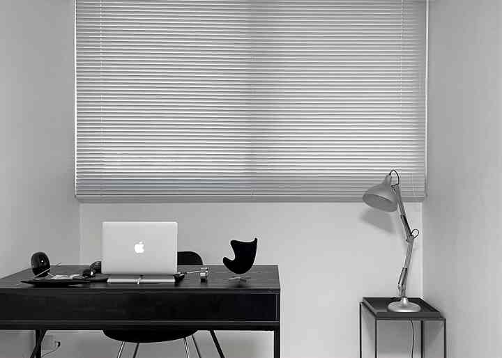 Monotone study room featuring a black desk and silver table lamp with a clean and minimal atmosphere