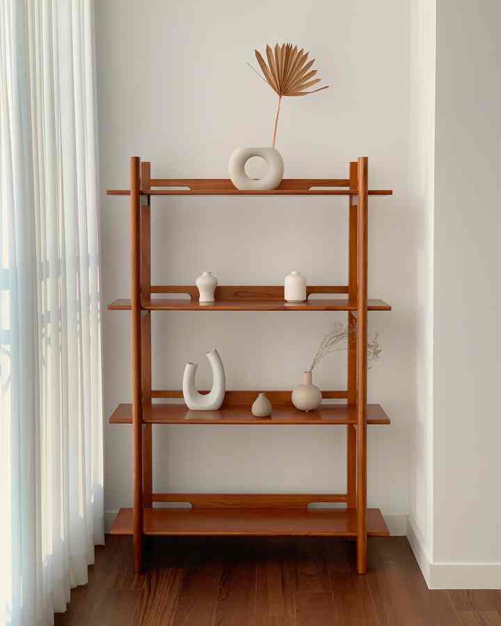 白い壁と木製の床を背景に、木製のシェルフに白い陶器のオブジェがシンプルに配置された、自然で落ち着いたリビングのインテリア