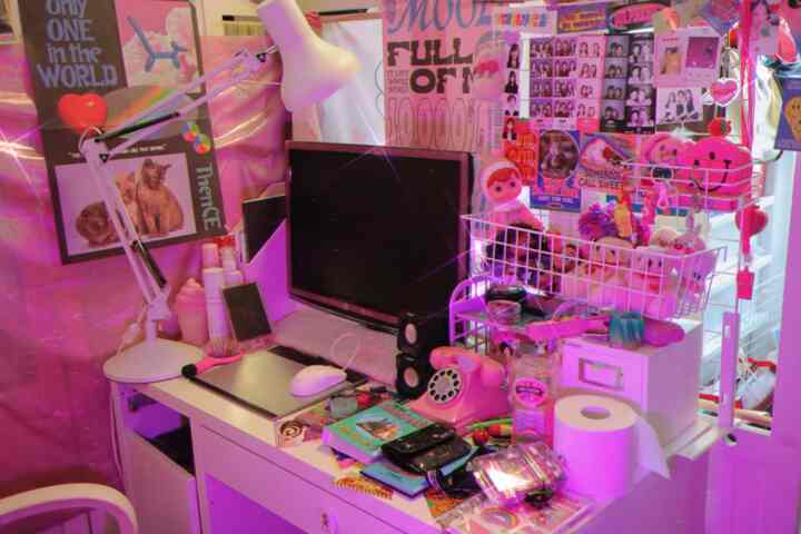 Retro style single household desk area with dominant purple lighting and kitsch decorative items creating a charming atmosphere