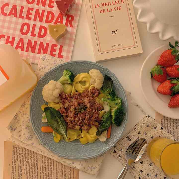 温かみのある色調のキッチンテーブル、青い皿に料理が盛られた居心地の良いホームダイニングのインテリア