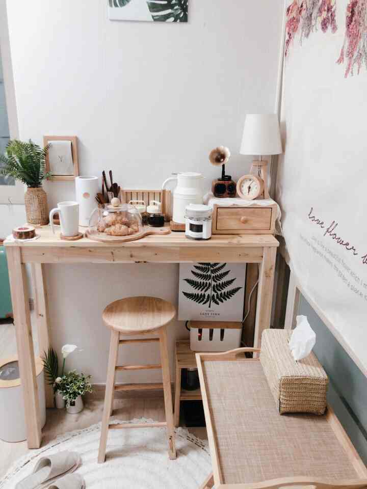 Wood tone and white home bar styled as a home cafe, featuring wooden bar table, bar stool, and rattan decor creating a natural vibe