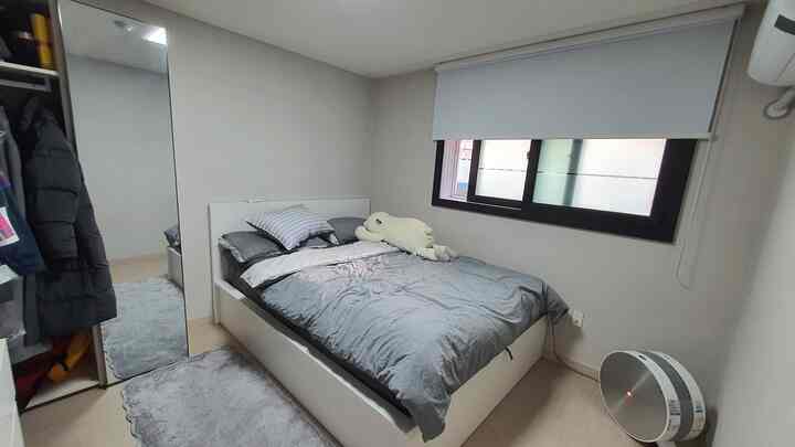 White and gray toned newlywed bedroom featuring a large bed and blinds creating a cozy space