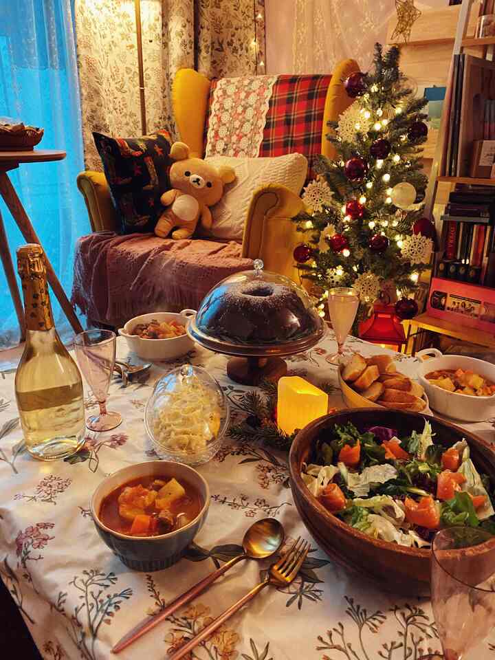 A cozy dining room with yellow armchair and Christmas tree, festive Christmas dinner spread on floral tablecloth