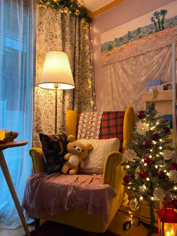 黄色とゴールドの色調が印象的な居心地の良いリビング、黄色のアームチェアとクリスマスツリー、フロアランプが配置された温かみのあるインテリア