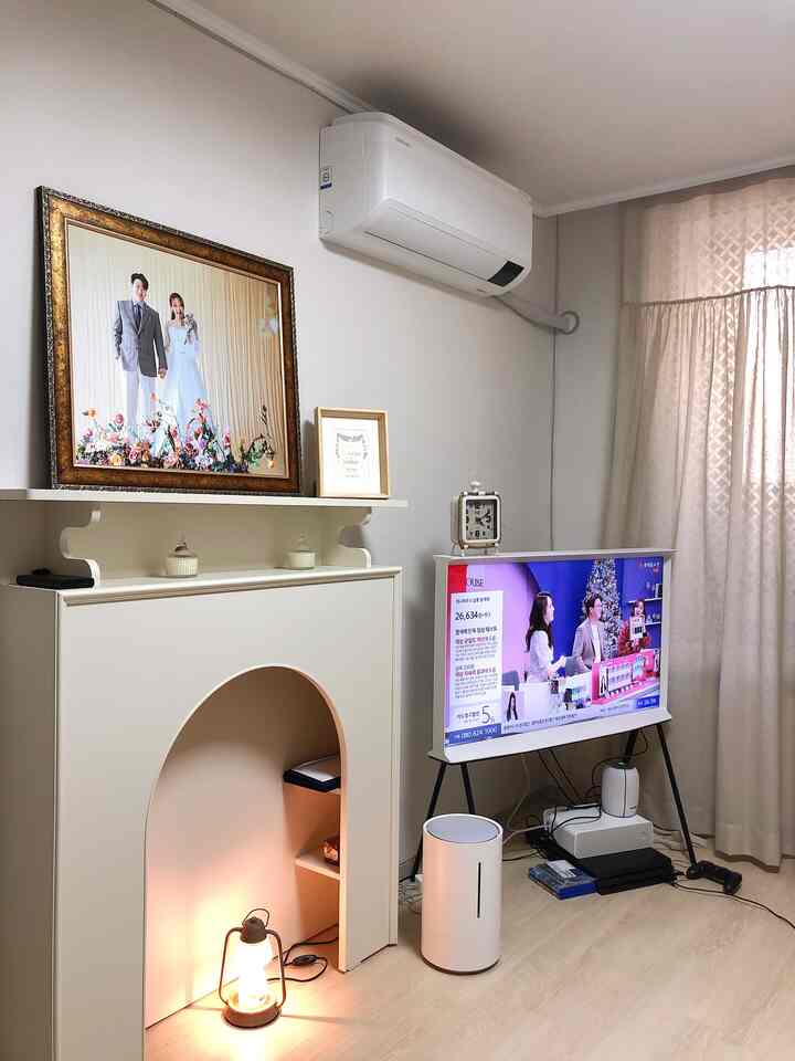 White-toned living room featuring a fireplace console and TV, presenting a clean and modern space