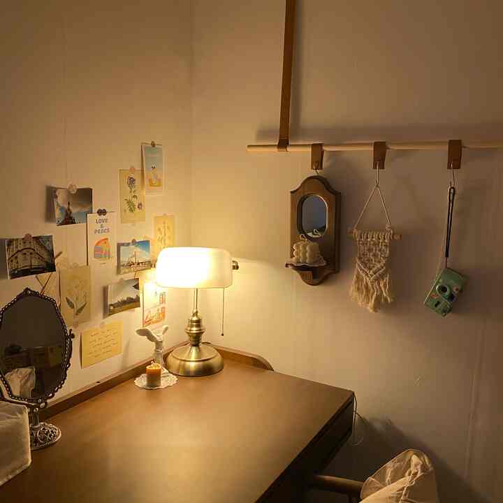 Warm natural-colored small space featuring a wooden desk, table lamp, and wall decor creating a cozy home office ambiance