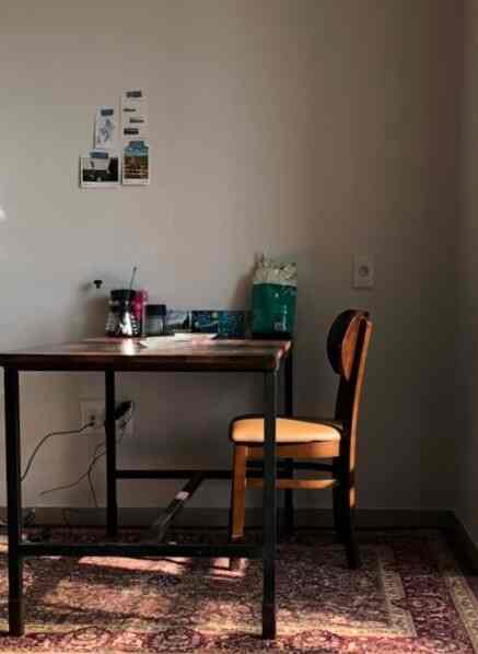 温かみのある木目調と白壁の6畳程度の小さな部屋、メルバウ製のダイニングテーブルと椅子が配置されたナチュラルモダンなインテリア