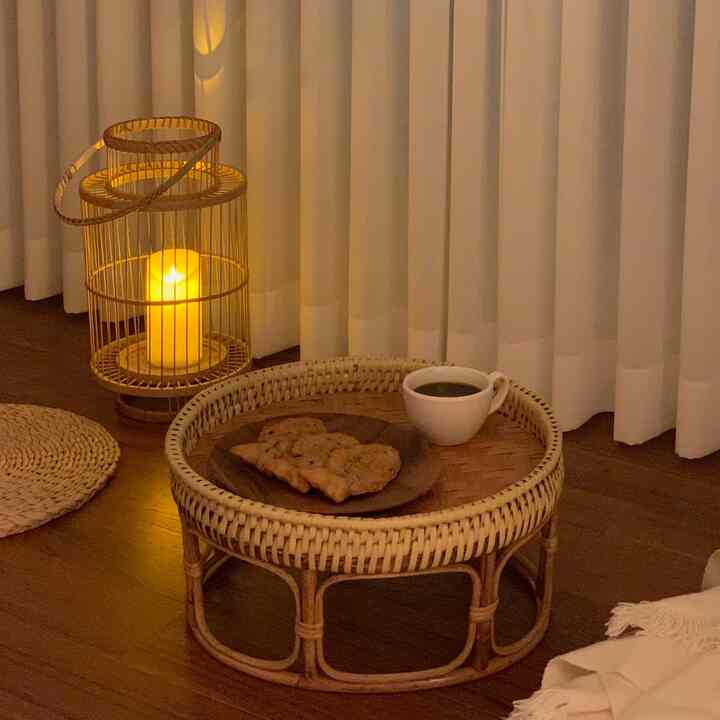 Cozy bedroom space with warm beige-toned rattan table and candle decor