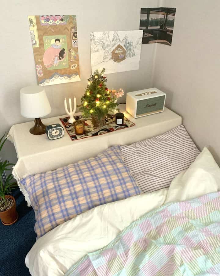Pastel-tone vintage-style studio bedroom featuring a decorated Christmas tree and cozy decorative accessories
