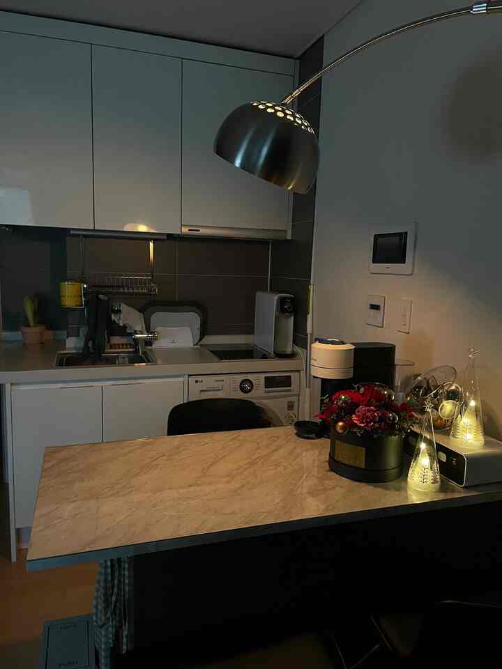 Natural tone kitchen space featuring marble island dining table and simple white cabinets with a clean interior style