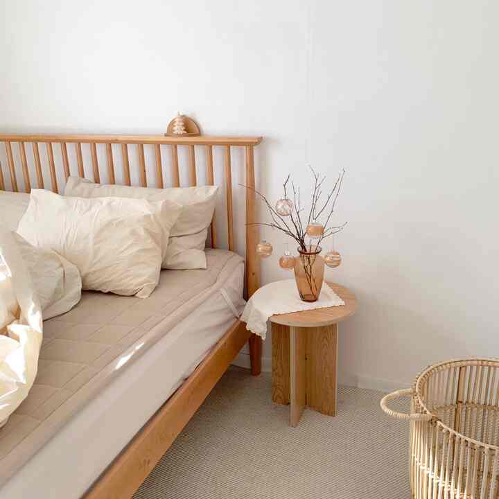 Beige and wood-toned bedroom with neat arrangement of a wooden bed and side table, creating a warm atmosphere