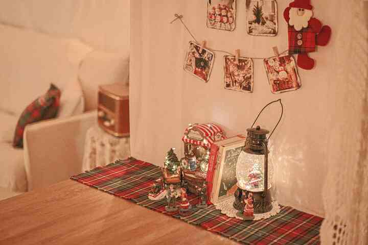 Cozy living room with warm natural-toned walls and wooden table featuring Christmas music box and miniature decorations