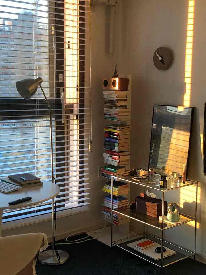 White and black living room featuring a desk and floor lamp creating a cozy home office atmosphere