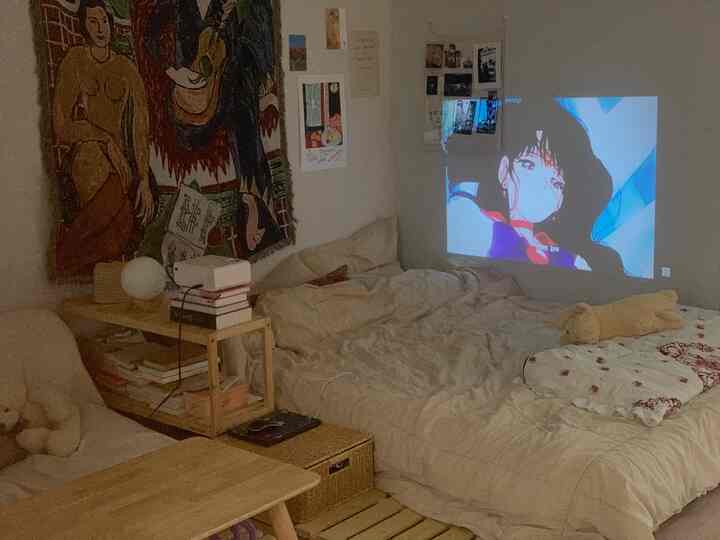 Cozy single household bedroom in beige and natural tones, featuring a projector for a warm home cinema space