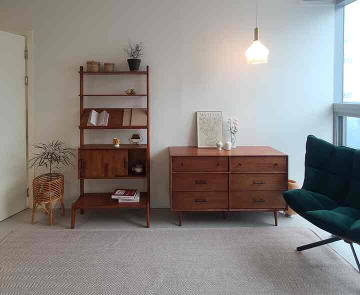 Natural wood-tone living room with wooden cabinets and a green armchair, creating a warm and cozy atmosphere
