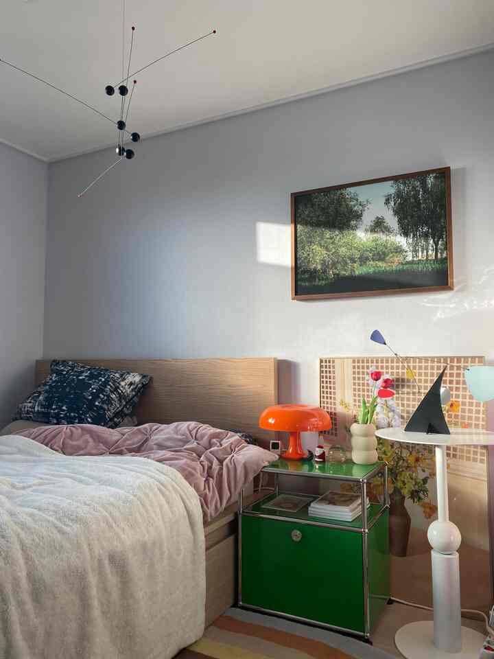 白と緑のトーンでまとめられた寝室、自然な木製ベッドとモダンな照明が配置されたミッドセンチュリーモダンの雰囲気のあるインテリア