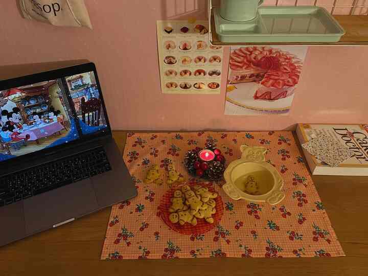 Warm wood desk featuring retro floral mat and home cafe elements creating a cozy ambiance