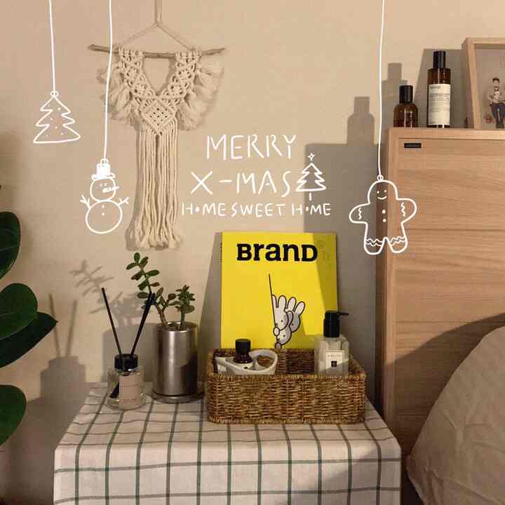 ベージュの壁と木目調家具がある寝室、ラタンバスケットとマクラメが配置された雰囲気のあるインテリア