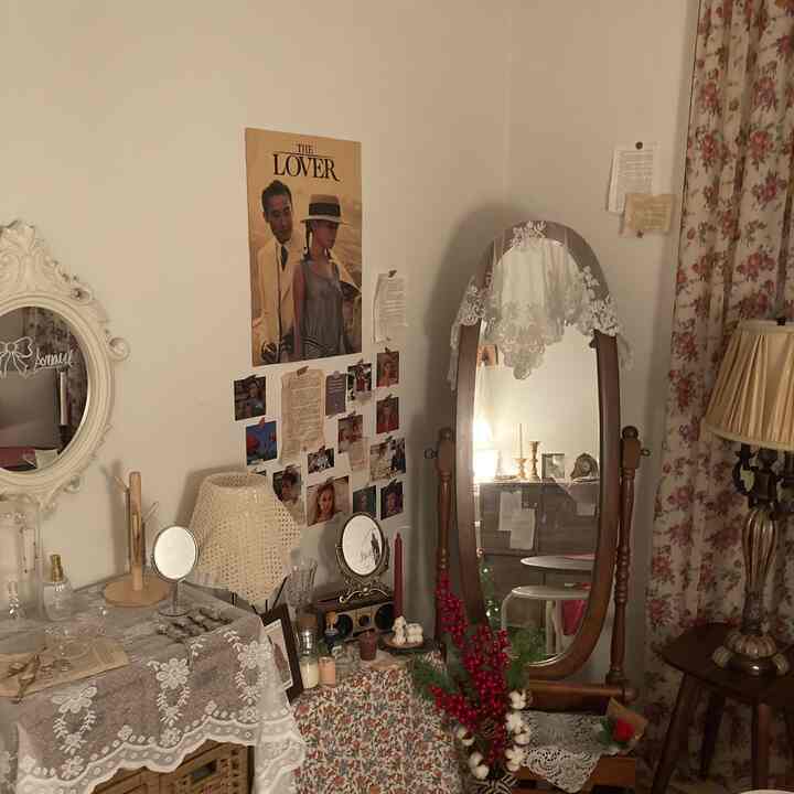 Cozy vintage-style space with white walls, wood-tone furniture, vintage poster, and floral curtains in a decorative setting