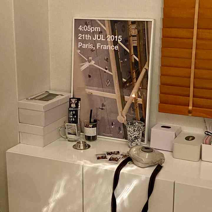 Modern space featuring a white console table with picture frame and wooden blinds, blending white and wood tones