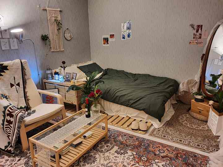 ナチュラルな木目調とボヘミアンスタイルの一人暮らし用寝室、木製家具とヴィンテージラグが調和した居心地の良い空間