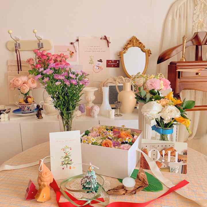 Pink and white toned interior featuring fresh flowers and vases with a natural and cozy atmosphere