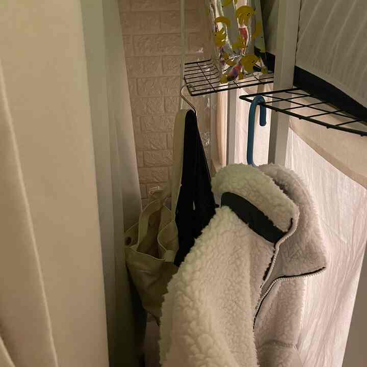 明るいアイボリーとベージュ色調の狭い寝室、隙間収納と犬用ゲートがある実用的な空間