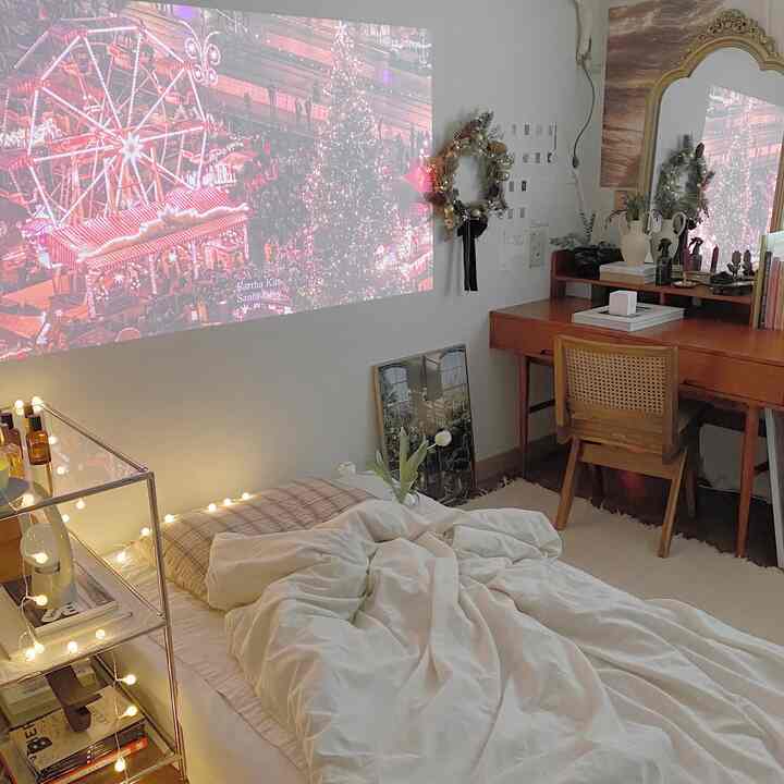 White and brown toned studio apartment featuring bed and desk with warm Christmas atmosphere