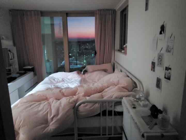 White-toned small bedroom featuring a metal bed frame and vanity dresser with a cozy atmosphere