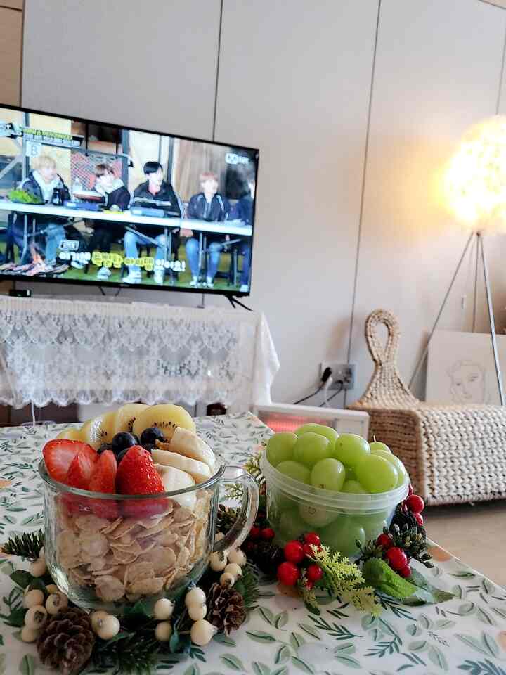 Calm-toned living room featuring a TV, rattan chair, and floor lamp creating a cozy atmosphere