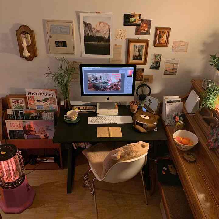 暖かいウッドトーンとブラックデスクが調和した書斎、額縁や植物が配置された雰囲気のあるホームオフィス