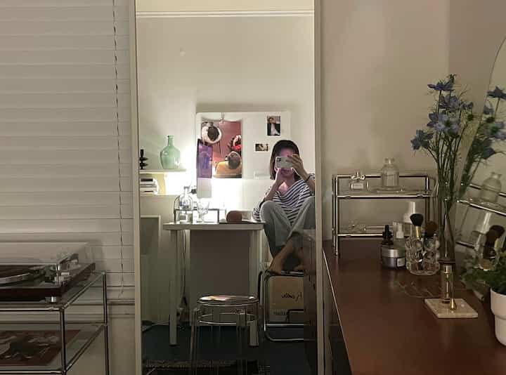 Beige and transparent toned home office and home cafe space featuring a full-length mirror and turntable, with modern cozy interior