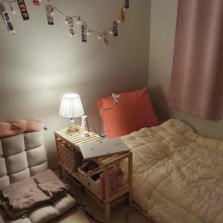 Natural tone single household bedroom featuring wood nightstand, cozy and compact atmosphere