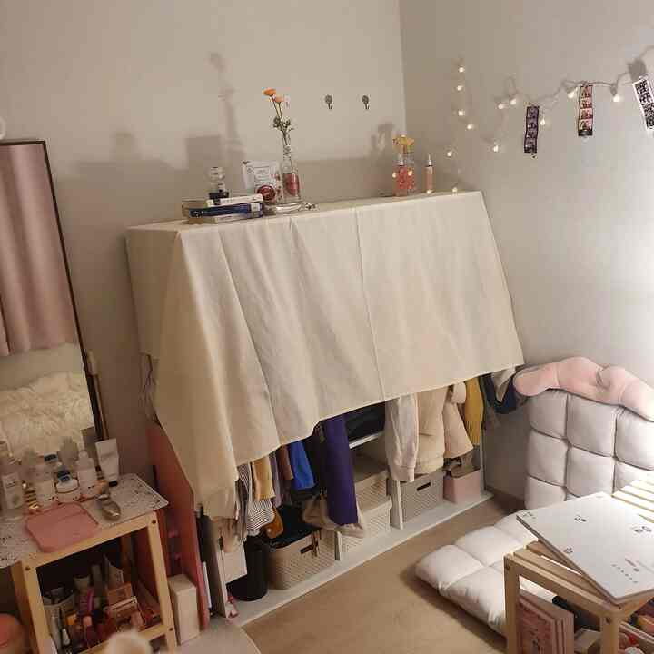Beige and white toned compact cozy living room featuring storage units and cushions with a relaxed atmosphere