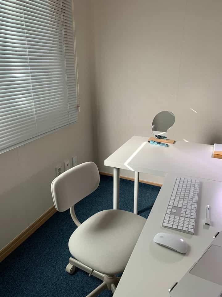 White-toned home office featuring white desk and chair in a clean, modern compact room