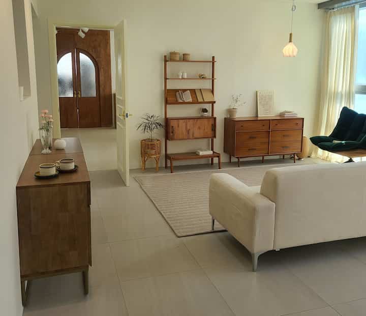 Warm wood-tone furniture and light beige curtains in a natural modern style living room