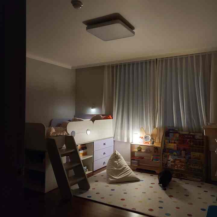 白とナチュラルカラーの子供部屋、子供用二段ベッドと本棚、ビーズクッションが配置された雰囲気ある空間