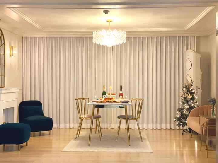 白とゴールドの調和が美しいシンプルモダンなリビング、シャンデリアとゴールドのダイニングチェアが配置された雰囲気のあるインテリア