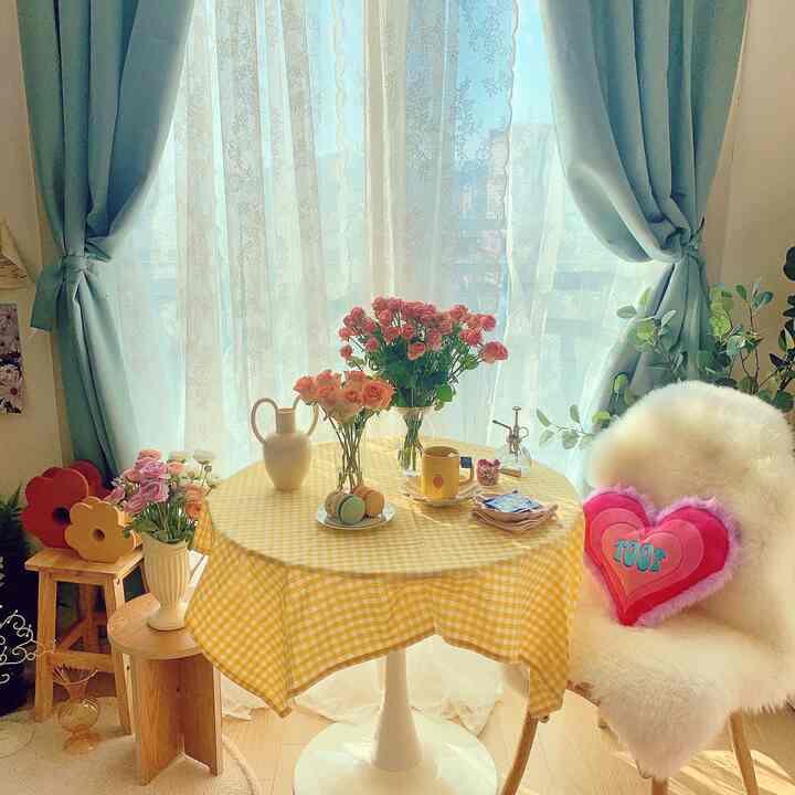 White and yellow toned round home cafe space featuring flowers, macarons on table, and cozy armchair creating a warm atmosphere
