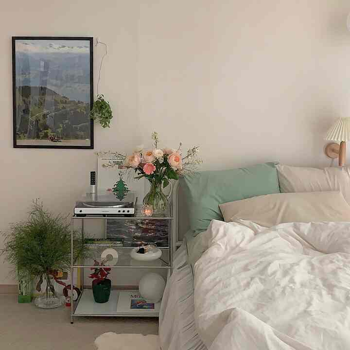 白とミント色調の寝室、モジュール収納とターンテーブル、ポスターが配置された自然な雰囲気のインテリア