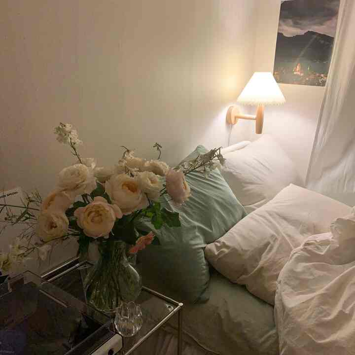 Bright white and beige bedroom featuring natural bedding and warm lighting creating a cozy atmosphere