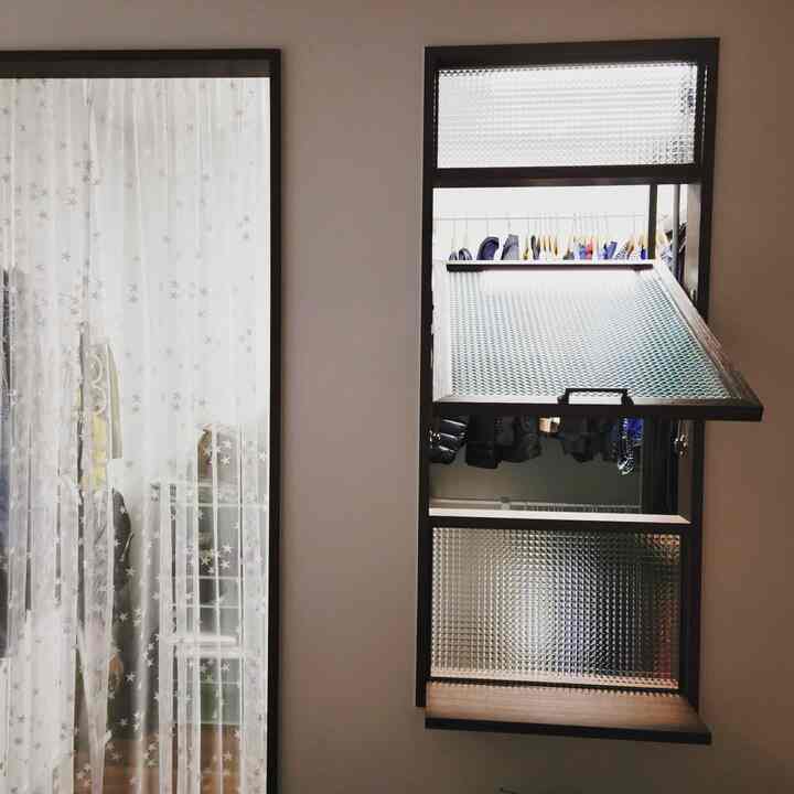 Quiet space featuring a brown-framed textured glass pivot window next to white curtains with star patterns