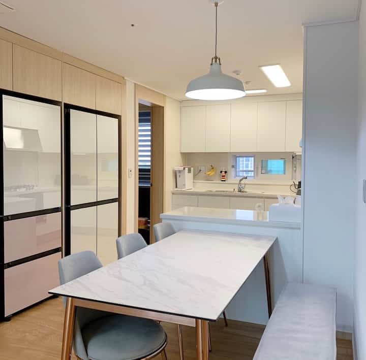 White and wood-tone kitchen and dining area with a modern, clean interior