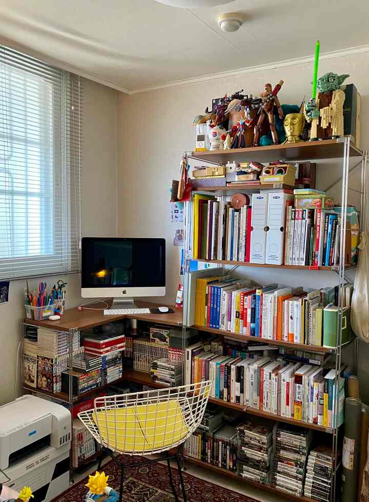 White and brown toned study room featuring bookshelves and a computer desk, creating a neat workspace