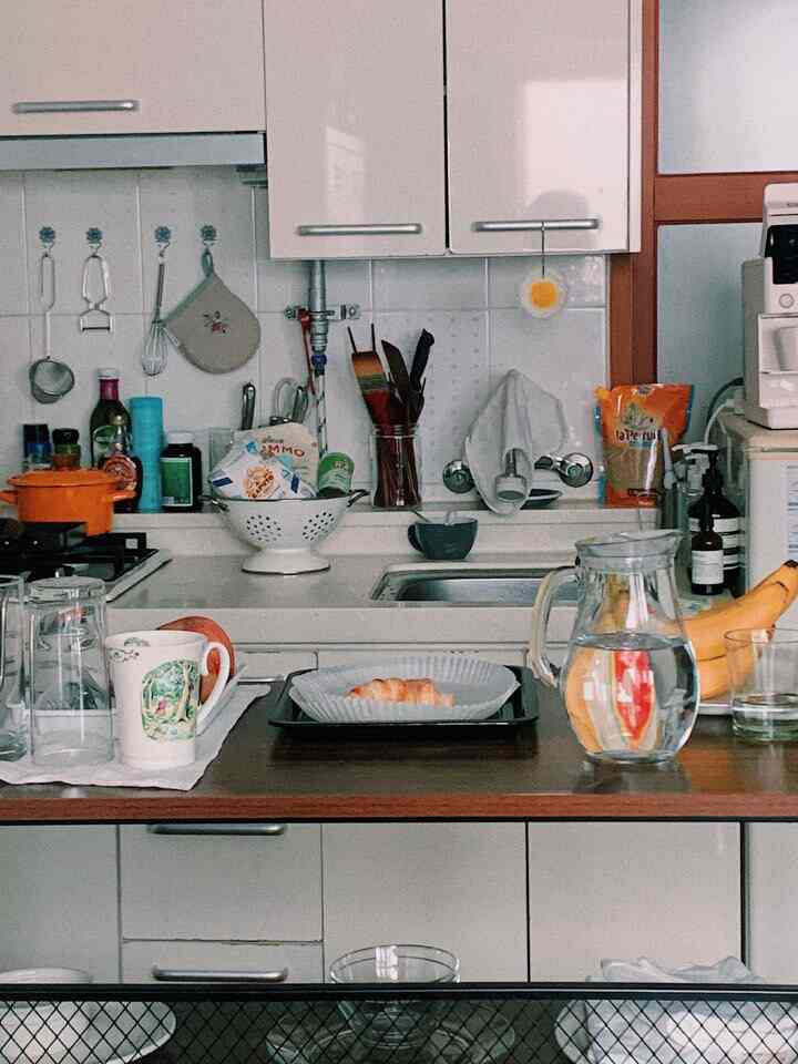 Natural-toned compact kitchen featuring vintage cookware and home cafe elements creating a cozy atmosphere