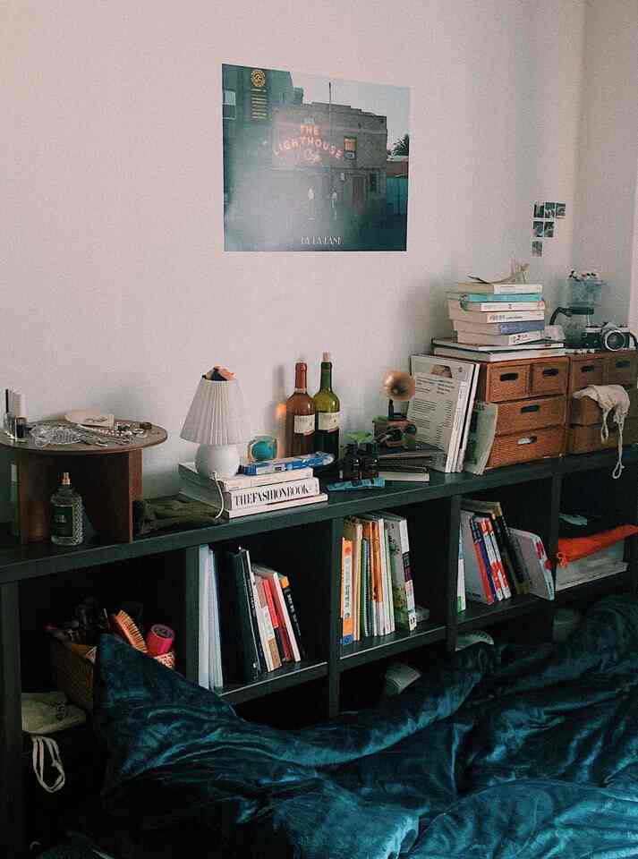 Dark green toned bedroom featuring bookshelf, vintage decor, and a poster in a cozy studio apartment